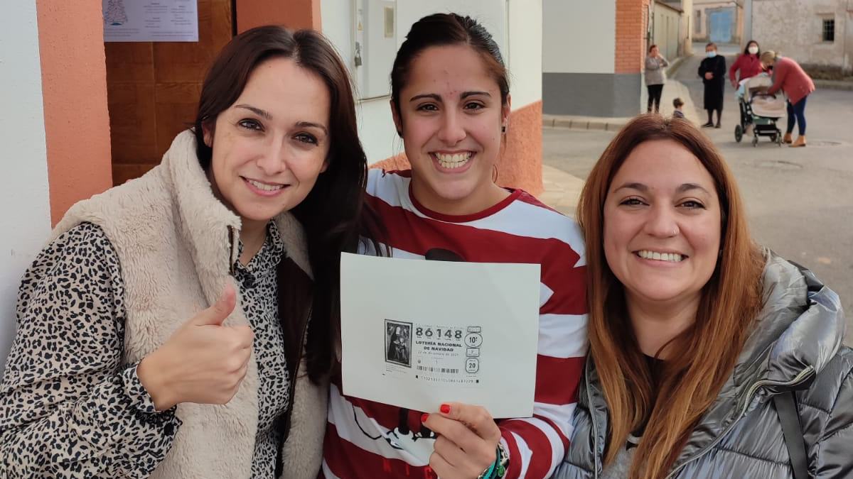 Carmen muestra el número de la Lotería de Navidad que les ha cambiado la vida