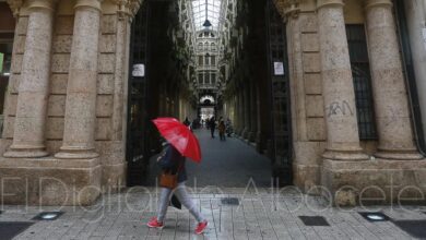 Una mujer camina bajo la lluvia frente al Pasaje Lodares de Albacete